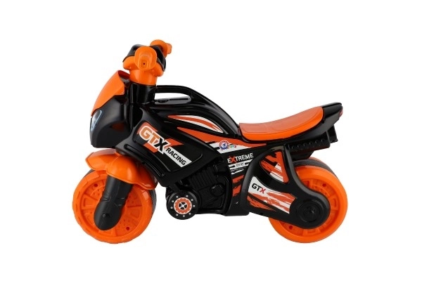 Moto trotteur orange-noir en plastique dans un sac 35x53x74cm 24m+